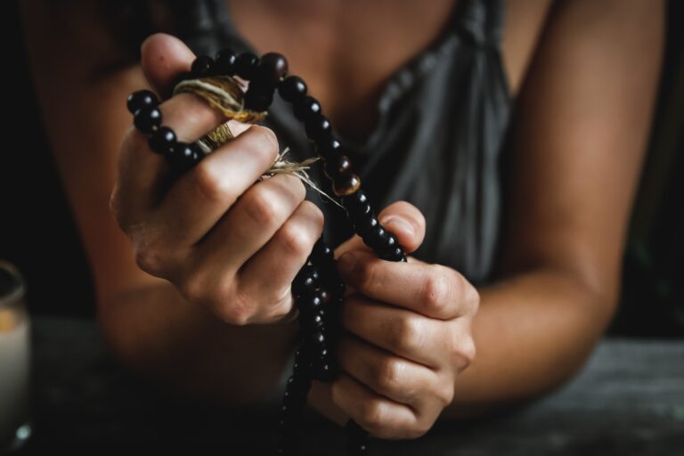 Women holding a black mala in her hands. Chandra Vida retreats.