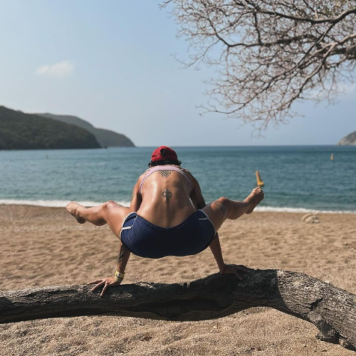 Caro striking a yoga pose at the beach. Chandra Vida Retreats.