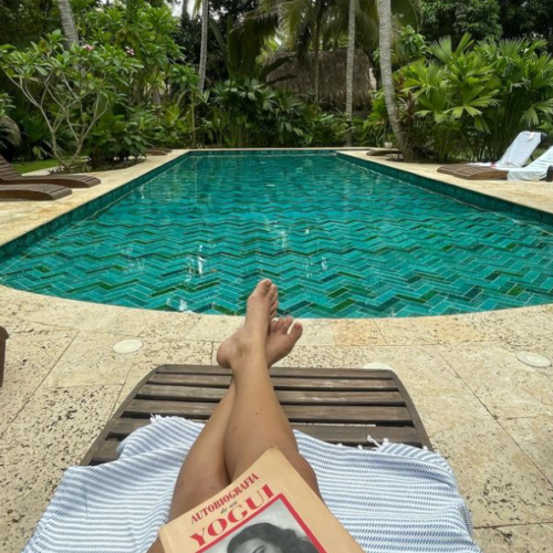 View of a students reading a book while sitting near the amazing pool. Chandra Vida Retreats.